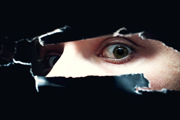 istock young man looking out of  hole in wall 120513578