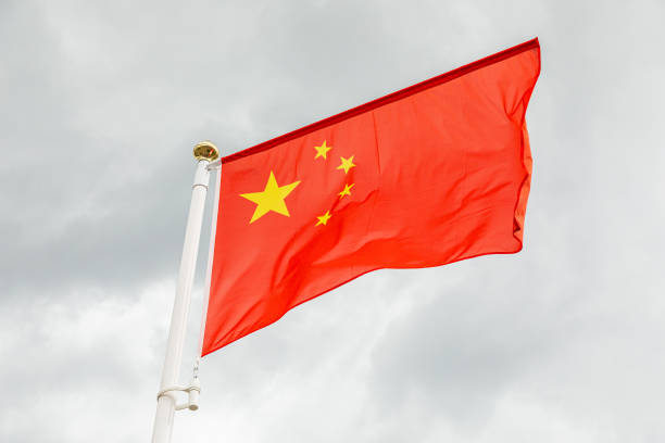 istock flag of China against white sky with clouds 1205136789
