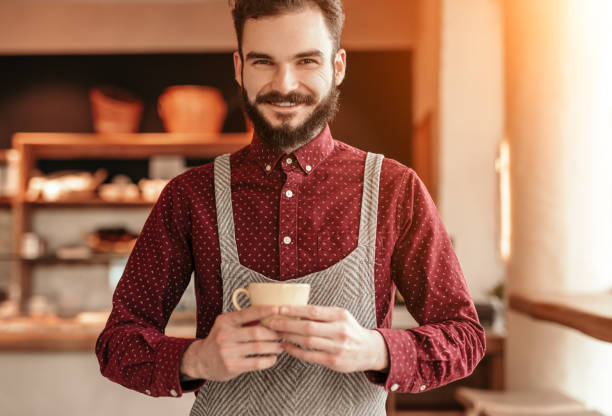 istock Friendly barista with cup of hot beverage 1205138576