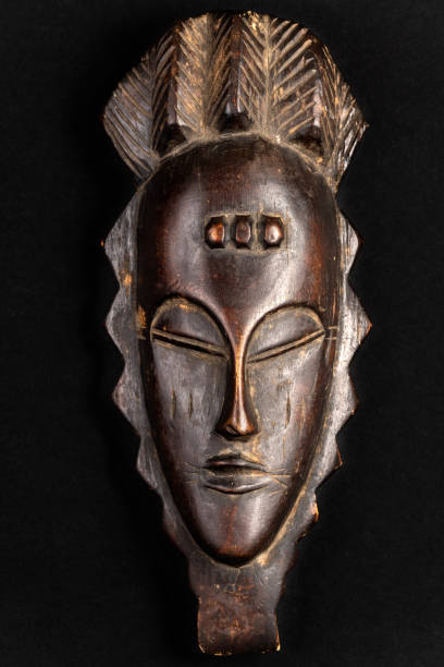 Carved African Mask Souvenir African mask souvenir isolated on a black background. Gift concept. antiquities photos stock pictures, royalty-free photos & images