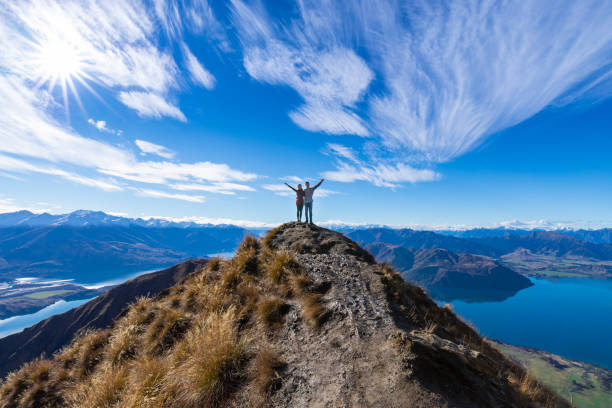 giovane coppia asiatica che festeggia il successo al roy's peak lake wanaka nuova zelanda - exploration mountain teamwork mountain peak foto e immagini stock