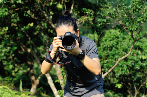 istock Photographer taking photo in the forest with digital camera 1205165542