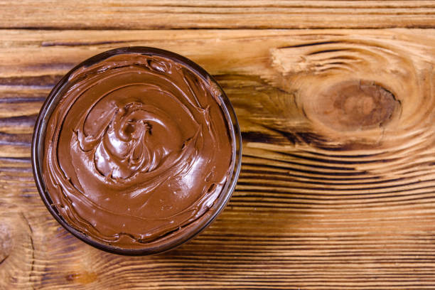 istock Glass bowl with chocolate spread on a wooden table. Top view 1205173622