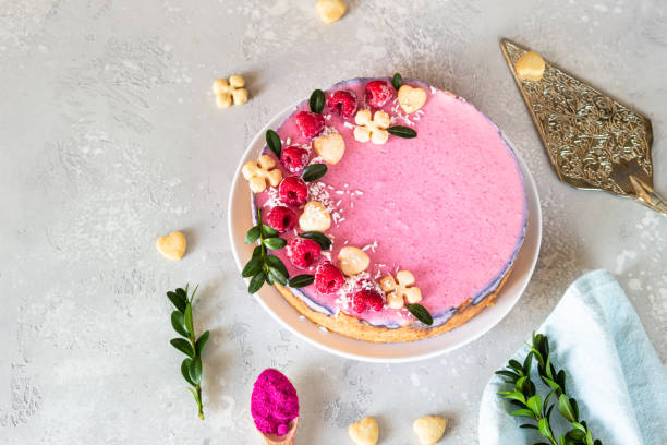 istock Raspberry cream mousse cake (no baked cheesecake) decorated with fresh raspberries, mini cookies and coconut flakes on light grey background. 1205177744