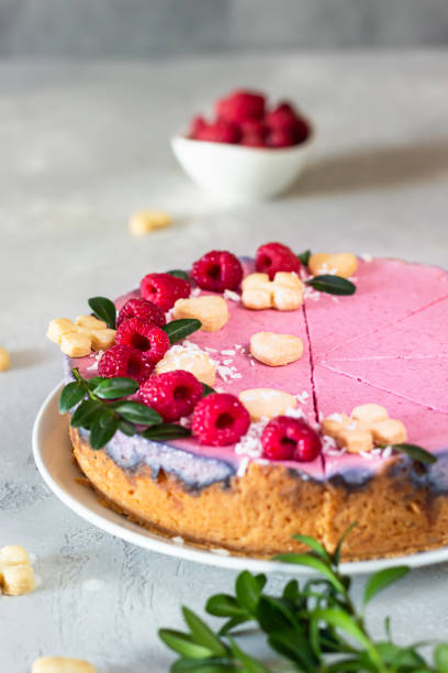 istock Raspberry cream mousse cake (no baked cheesecake) decorated with fresh raspberries, mini cookies and coconut flakes on light grey background. 1205177780