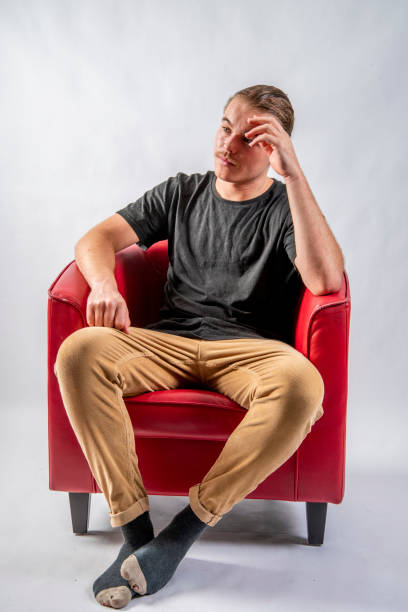 istock Attractive young man lounging in a Red Chair. 1205185792