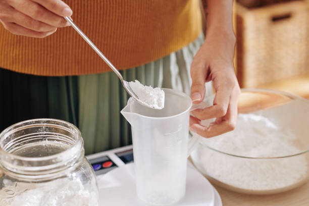 istock Woman putting spoon of lye in jar 1205187856