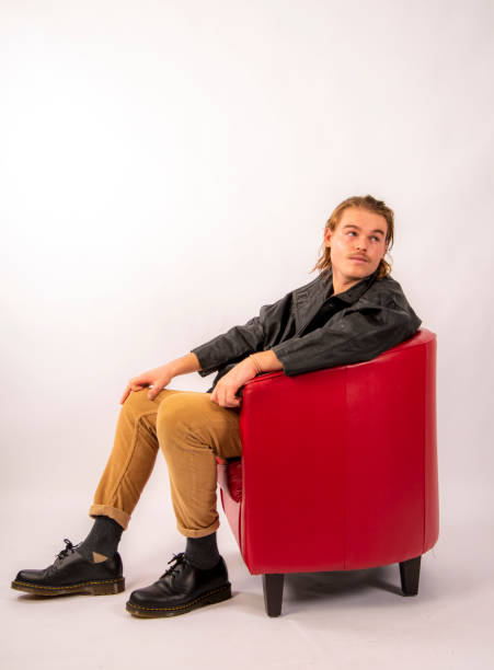 Attractive young man lounging in a Red Chair.