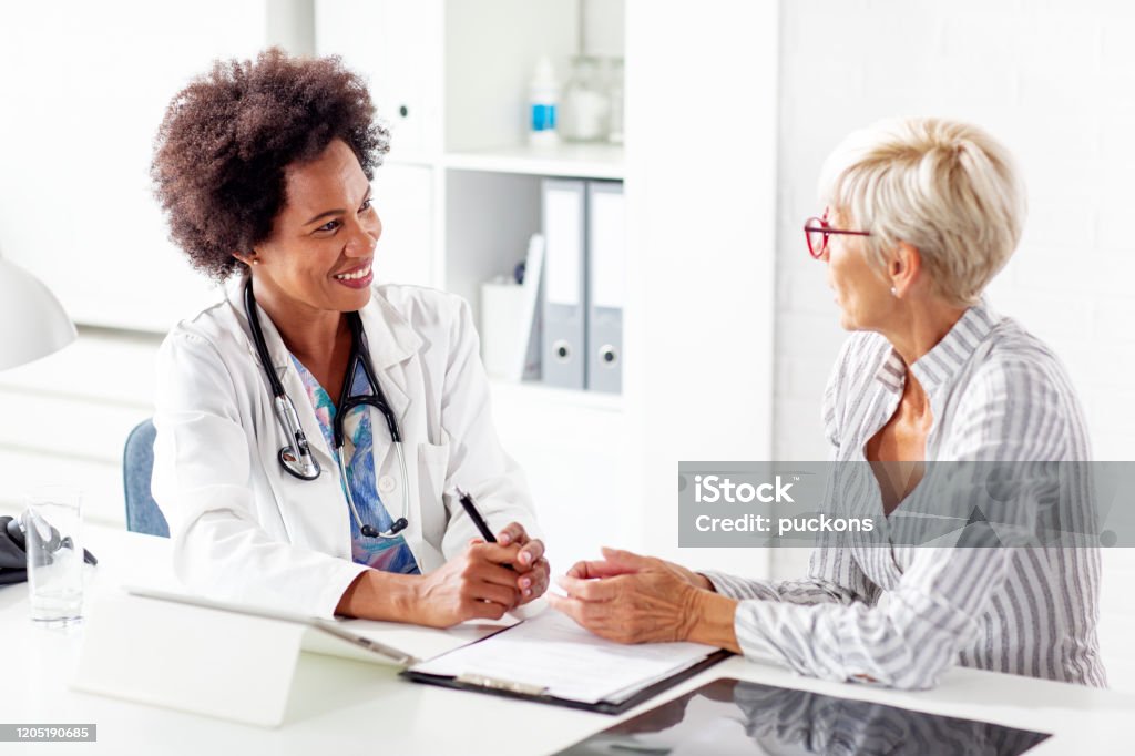 Mature woman talk with her doctor about health in clinic Doctor Stock Photo Mature woman talk with her doctor about health in clinic Doctor Stock Photo
