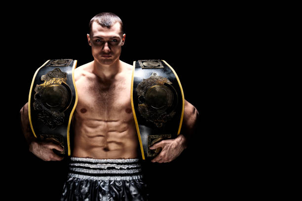 Kickboxing world middleweight champion stands with two belts. The concept of a healthy lifestyle, victory, success. Motivation. stock photo
