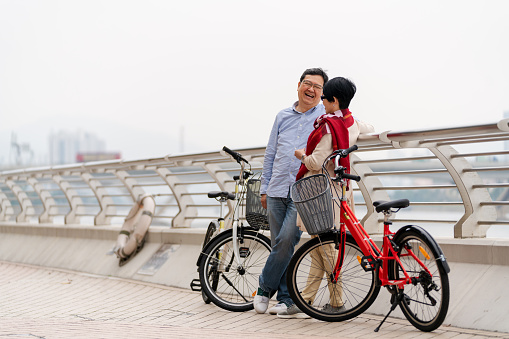 Mature asian couple taking a break from cycling. Hong Kong