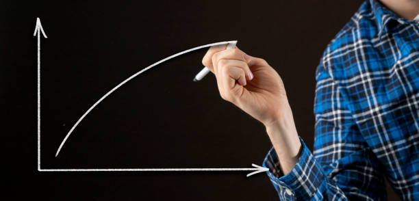 istock businessman drawing a rising graph on the wall glass 1205198684