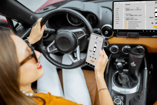 istock Woman controlling car with a smart phone 1205199167
