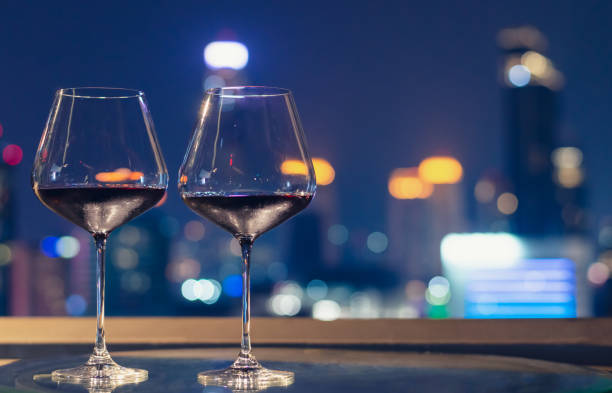 istock Two glasses of red wine on table of rooftop bar. 1205202911