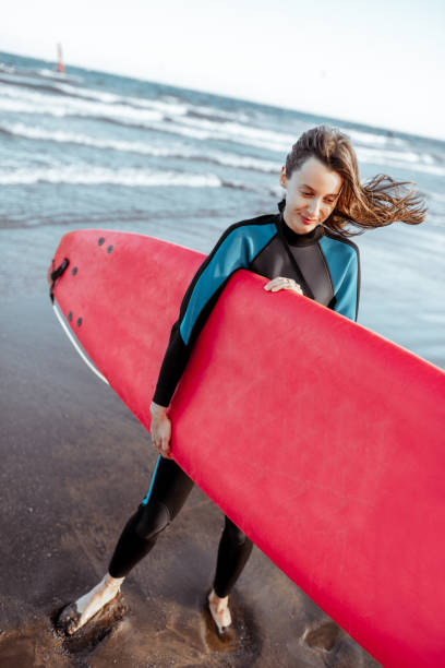 istock Woman with surfboard on the beach 1205203090