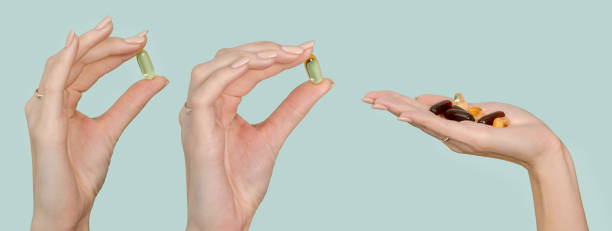 istock Omega 3 capsules and vitamin supplements on the human hand set isolated on blue background 1205203769