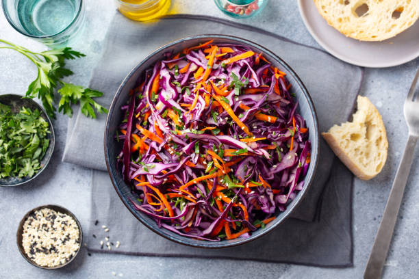 Red cabbage salad, Coleslaw in a bowl. Grey background. Top view.