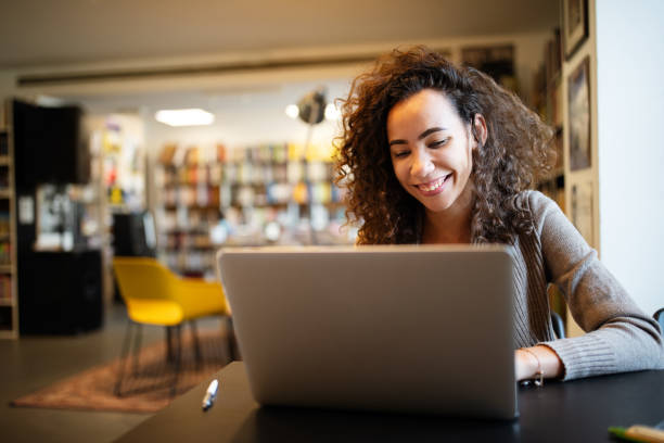 istock Young beautiful student girl working, learning in college library 1205211696