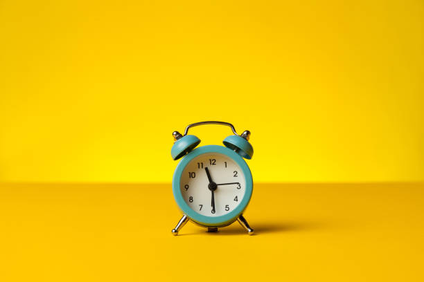 istock Working hours and overtime work. Hurry work, concept. Clock on yellow background 1205212394