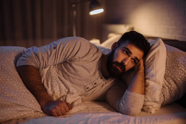 istock Depressed man lying in his bed and feeling bad 1205213510