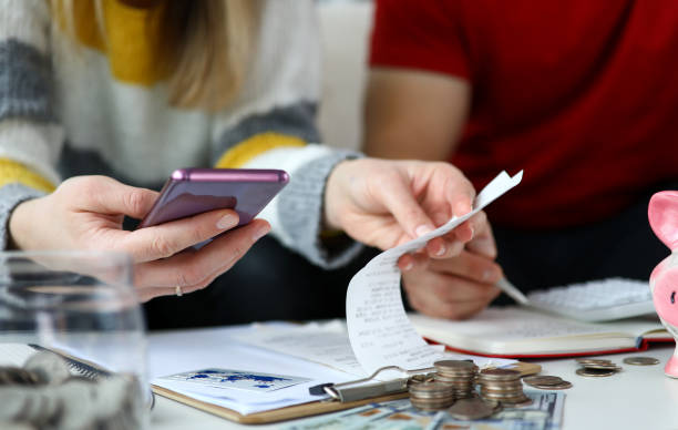 Review credit and debit Close-up view of woman looking through checks and calculating expenses. Plastic card and coins laying on desktop. Man planning family budget. Economy concept capital budget pictures stock pictures, royalty-free photos & images