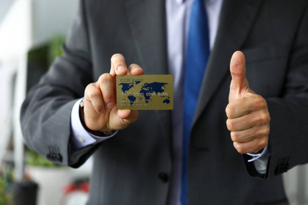 istock Man in suit and tie holding banking card 1205213682