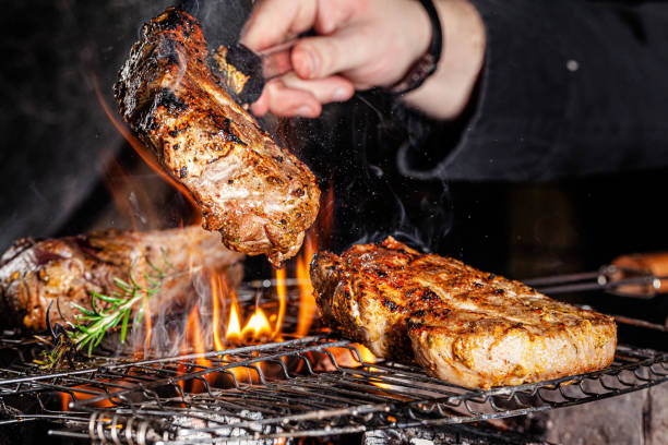 istock Chef cook fries meat, beef steak on an open fire in a restaurant. background image, copy space text 1205217476