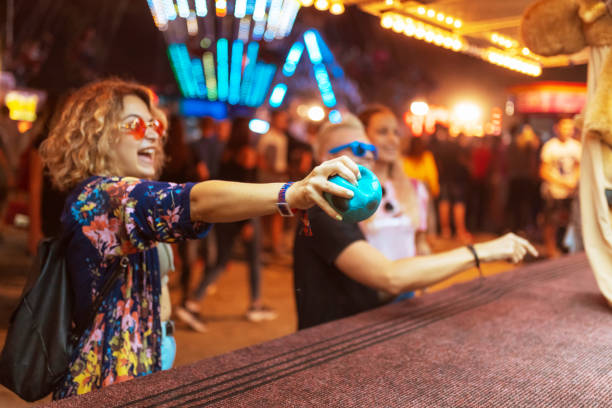 istock Woman throwing soft ball at amusement park 1205220367