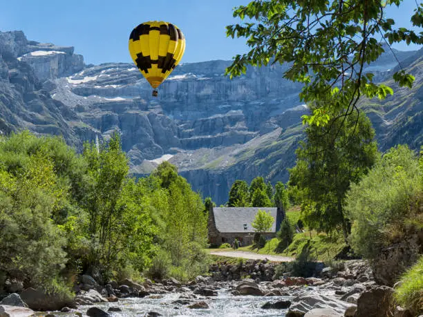 Photo of a view of Cirque de Gavarnie with yellow hot air balloon, Hautes-Pyrenees, France