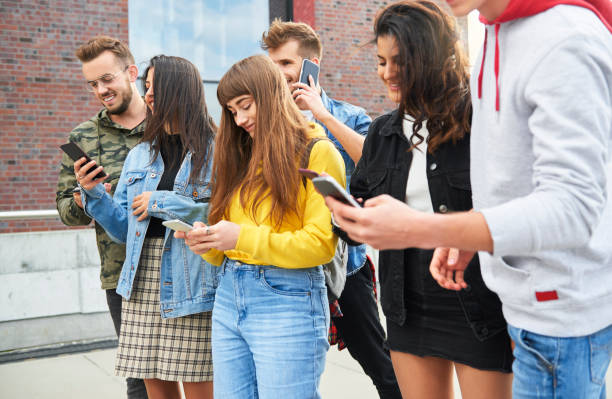 istock Young people with mobile phones standing in a row 1205223602