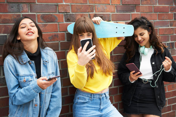 istock Three young women having fun with mobile phone 1205224435