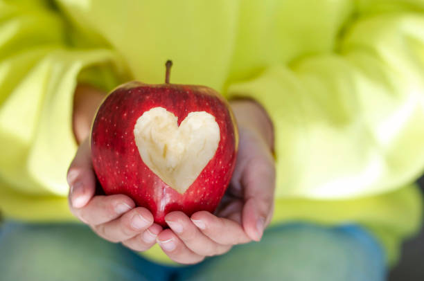 mela rossa con simbolo di cuore - apple missing bite fruit red foto e immagini stock