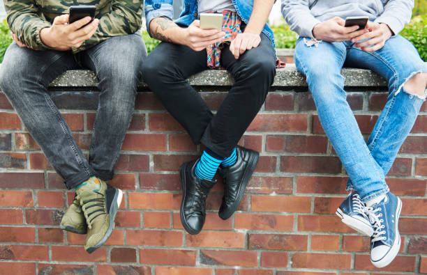 istock Close up of three young men using mobile phone 1205226693