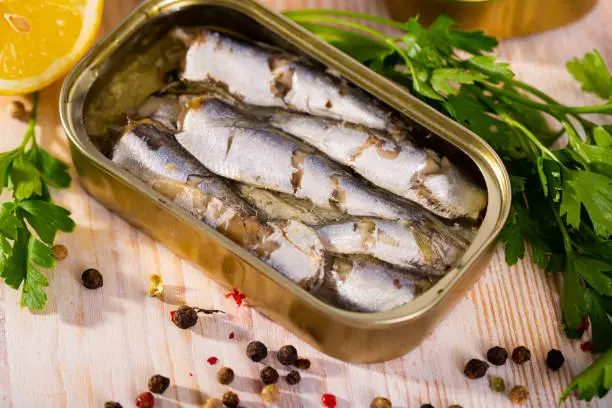 Open can of sardines on table