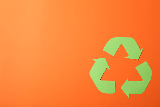 istock Recycling sign on orange background, top view 1205228281