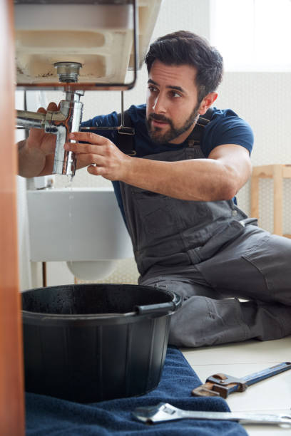 istock Male Plumber Working To Fix Leaking Sink In Home Bathroom 1205228868