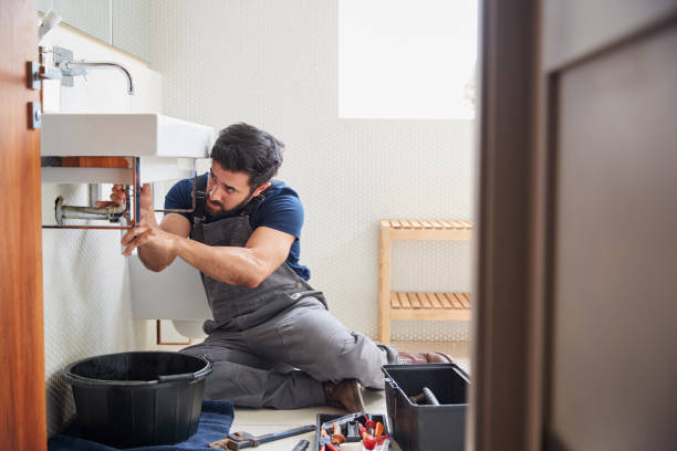 istock Male Plumber Working To Fix Leaking Sink In Home Bathroom 1205228909