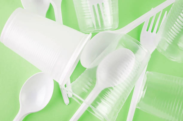 istock White Disposable cups, plates, forks, knives on background close-up - Environmental problem concept 1205229829