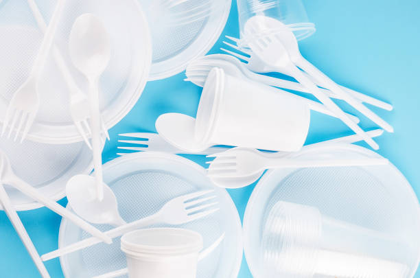istock White Disposable cups, plates, forks, knives on background close-up - Environmental problem concept 1205229856