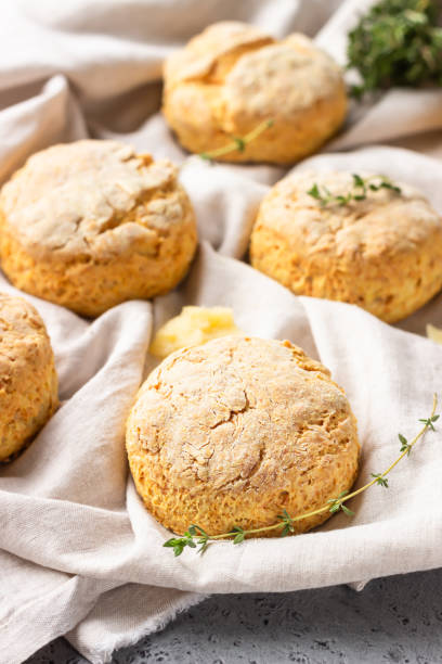 istock Cheese scones, pieces of cheese and thyme on a grey napkin. Grey stone background, toned image. 1205230302