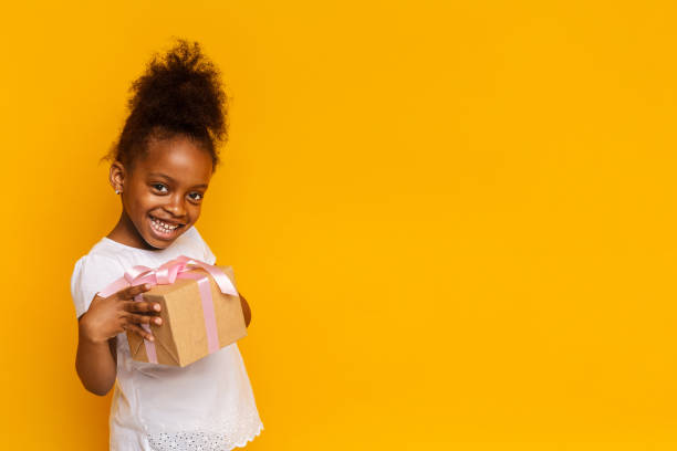 istock Cute little girl smiling and holding gift box 1205230902