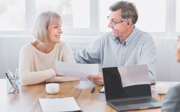 istock Mature couple talking to financial advisor at office 1205232087