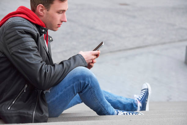 istock Side view of young man using his smart phone 1205232245