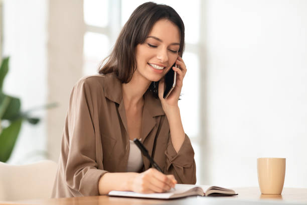 istock Portrait of smiling manager making phone call and writing 1205232315