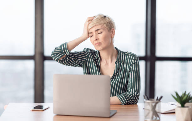 istock Lady Touching Head Suffering From Pain Sitting In Modern Office 1205232362
