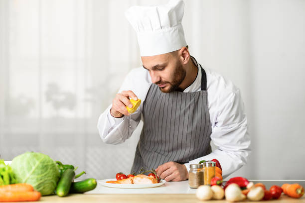 istock Chef Cooking Fish Squeezing Lemon On Salmon Steak In Kitchen 1205232460