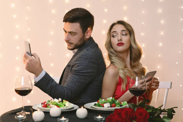 istock Curious Woman Peeking Into Boyfriend's Smartphone During Romantic Dinner In Restaurant 1205232526
