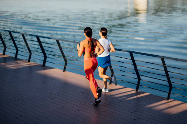 istock Women jogging next to a river 1205233839