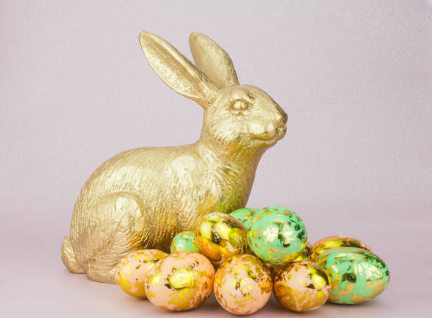 istock gold bunny rabbit in pink  background  with Easter gold egg 1205234214