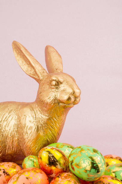 istock gold bunny rabbit in pink  background  with Easter gold egg 1205234263